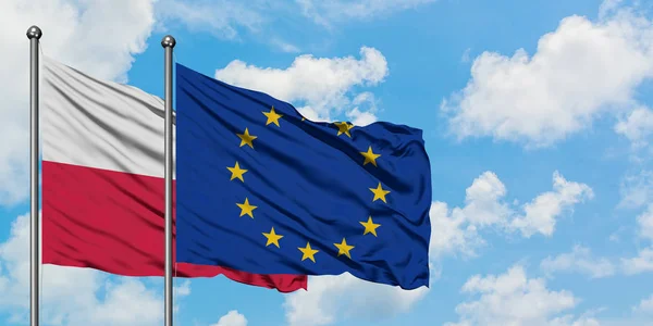 La Polonia e l'Unione europea sventolano insieme la bandiera contro il bianco cielo blu nuvoloso. Concetto di diplomazia, relazioni internazionali . — Foto Stock