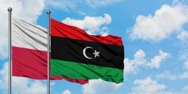Polonya ve Libya bayrağı birlikte beyaz bulutlu mavi gökyüzüne karşı rüzgarda sallayarak. Diplomasi kavramı, uluslararası ilişkiler.