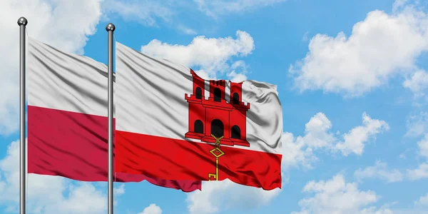 A Polônia e a bandeira de Gibraltar agitando no vento contra o céu azul nublado branco juntos. Conceito de diplomacia, relações internacionais . — Fotografia de Stock