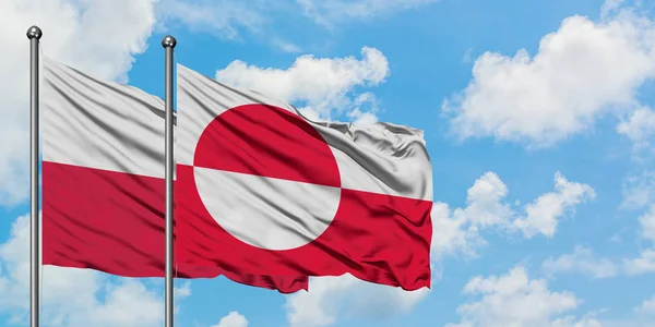 Polsko a Grónská vlajka mávali ve větru proti bíle zatažené modré obloze. Diplomacie, mezinárodní vztahy. — Stock fotografie