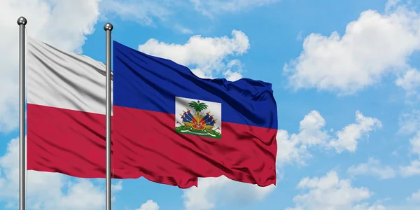 Polonya ve Haiti bayrağı birlikte beyaz bulutlu mavi gökyüzüne karşı rüzgarda sallayarak. Diplomasi kavramı, uluslararası ilişkiler. — Stok fotoğraf