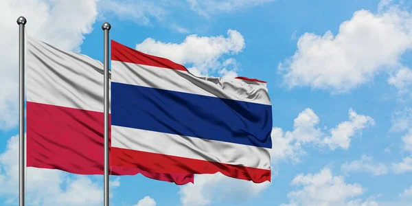 Bandera de Polonia y Tailandia ondeando en el viento contra el cielo azul nublado blanco juntos. Concepto diplomático, relaciones internacionales . — Foto de Stock