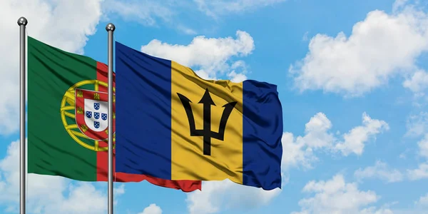 Portugal och Barbados flagga viftande i vinden mot vit grumlig blå himmel tillsammans. Diplomatisk koncept, internationella relationer. — Stockfoto