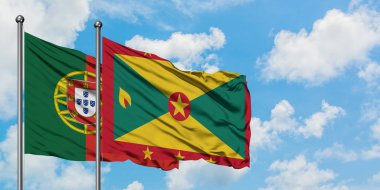 Portekiz ve Grenada bayrağı birlikte beyaz bulutlu mavi gökyüzüne karşı rüzgarda sallayarak. Diplomasi kavramı, uluslararası ilişkiler.