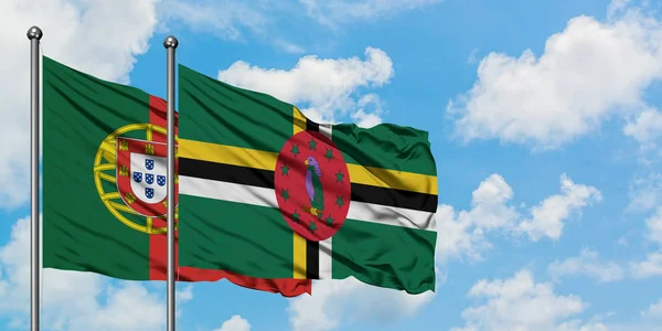 Portugal och Dominica flagga viftande i vinden mot vit grumlig blå himmel tillsammans. Diplomatisk koncept, internationella relationer. — Stockfoto