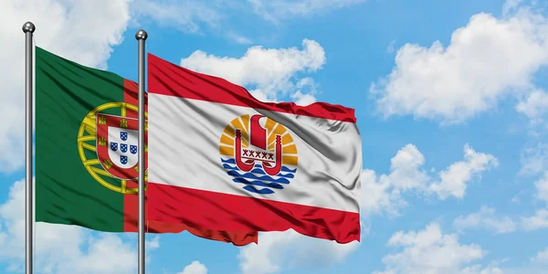 Bandera de Portugal y Polinesia Francesa ondeando en el viento contra el cielo azul nublado blanco juntos. Concepto diplomático, relaciones internacionales . — Foto de Stock