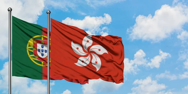 Portugal e a bandeira de Hong Kong agitando no vento contra o céu azul nublado branco juntos. Conceito de diplomacia, relações internacionais . — Fotografia de Stock