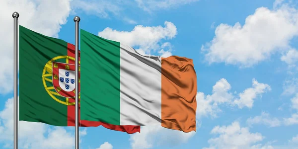 Portogallo e Irlanda sventolano insieme la bandiera contro il bianco cielo blu nuvoloso. Concetto di diplomazia, relazioni internazionali . — Foto Stock