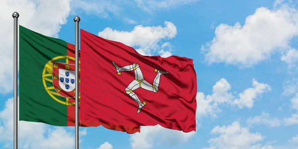Portugal och Isle of man flagga vifta i vinden mot vit grumlig blå himmel tillsammans. Diplomatisk koncept, internationella relationer. — Stockfoto