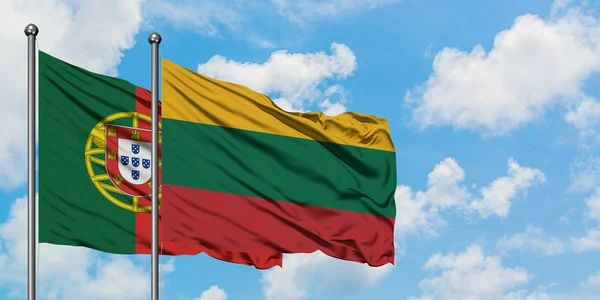 Bandeira de Portugal e Lituânia agitando no vento contra o céu azul nublado branco juntos. Conceito de diplomacia, relações internacionais . — Fotografia de Stock