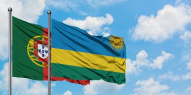 Portekiz ve Ruanda bayrağı birlikte beyaz bulutlu mavi gökyüzüne karşı rüzgarda sallayarak. Diplomasi kavramı, uluslararası ilişkiler.