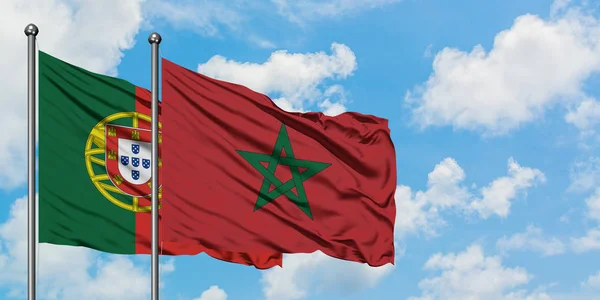 Bandera de Portugal y Marruecos ondeando en el viento contra el cielo azul nublado blanco juntos. Concepto diplomático, relaciones internacionales . — Foto de Stock