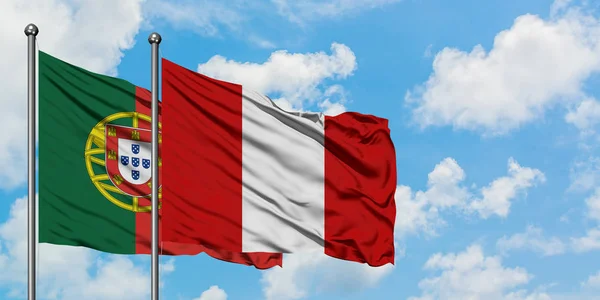 Bandera de Portugal y Perú ondeando en el viento contra el cielo azul nublado blanco juntos. Concepto diplomático, relaciones internacionales . — Foto de Stock