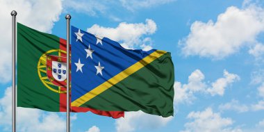 Portekiz ve Solomon Adaları bayrağı birlikte beyaz bulutlu mavi gökyüzüne karşı rüzgarda sallayarak. Diplomasi kavramı, uluslararası ilişkiler.