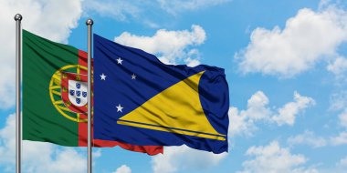 Portekiz ve Tokelau bayrağı birlikte beyaz bulutlu mavi gökyüzüne karşı rüzgarda sallayarak. Diplomasi kavramı, uluslararası ilişkiler.