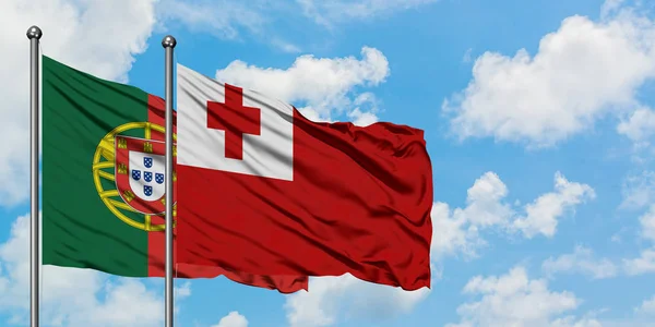 Portogallo e bandiera Tonga sventolano insieme nel vento contro il bianco cielo blu nuvoloso. Concetto di diplomazia, relazioni internazionali . — Foto Stock