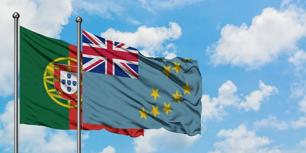 Bandera de Portugal y Tuvalu ondeando en el viento contra el cielo azul nublado blanco juntos. Concepto diplomático, relaciones internacionales . — Foto de Stock