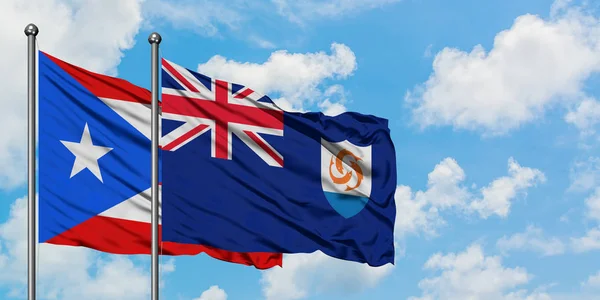 波多黎各和安圭拉国旗在风中飘扬，与白云蓝天相一起。外交概念、国际关系. — 图库照片
