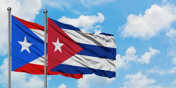 一緒に白い曇った青い空に対して風に手を振るプエルトリコとキューバの旗。外交概念、国際関係. — ストック写真