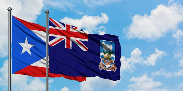 波多黎各和福克兰群岛国旗在风中飘扬，与白云蓝天相一起。外交概念、国际关系. — 图库照片
