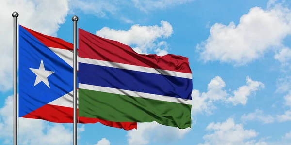 Пуерто-Ріко і Гамбія прапор розмахував вітром проти білого хмарного синього неба разом. Концепція дипломатії, міжнародні відносини. — стокове фото