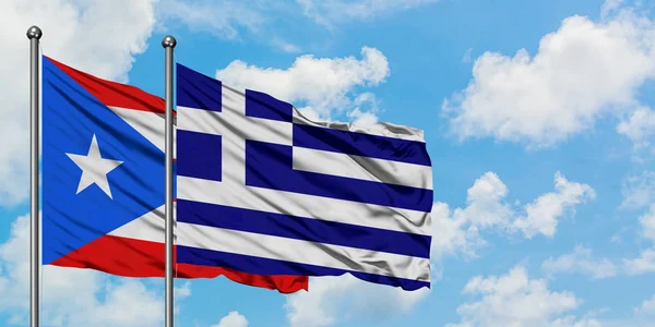 Bandera de Puerto Rico y Grecia ondeando en el viento contra el cielo azul nublado blanco juntos. Concepto diplomático, relaciones internacionales . — Foto de Stock