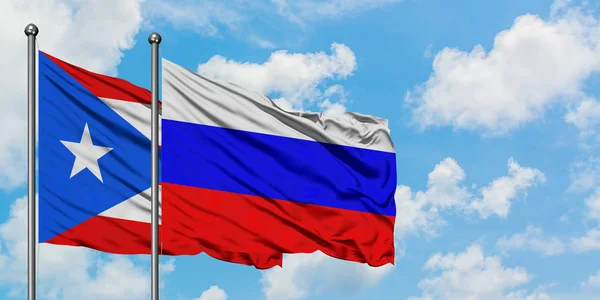 Пуерто-Ріко і Росія прапор розмахуючи в вітер проти білого хмарного синього неба разом. Концепція дипломатії, міжнародні відносини. — стокове фото