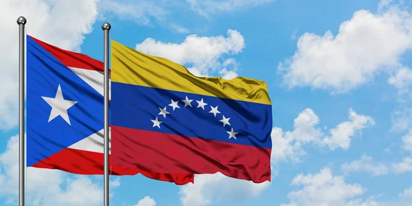 Puerto Rico and Venezuela flag waving in the wind against white cloudy blue sky together. Diplomacy concept, international relations. — Stock Photo, Image