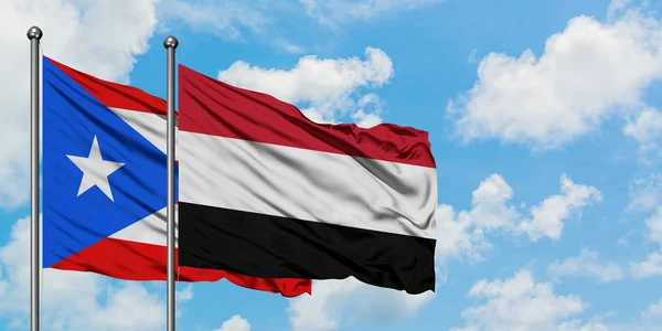 Пуерто-Ріко і Ємен прапор розмахуючи в вітер проти білого хмарного синього неба разом. Концепція дипломатії, міжнародні відносини. — стокове фото