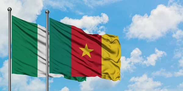 Bandera de Nigeria y Camerún ondeando en el viento contra el cielo azul nublado blanco juntos. Concepto diplomático, relaciones internacionales . — Foto de Stock