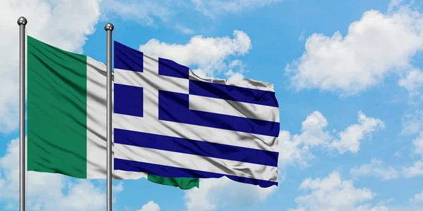 Nijerya ve Yunanistan bayrağı birlikte beyaz bulutlu mavi gökyüzüne karşı rüzgarsal sallayarak. Diplomasi kavramı, uluslararası ilişkiler. — Stok fotoğraf