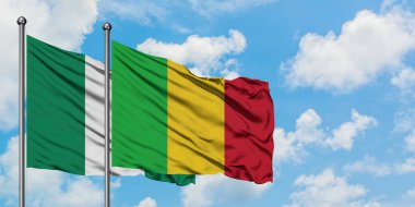 Nijerya ve Mali bayrağı birlikte beyaz bulutlu mavi gökyüzüne karşı rüzgarda sallayarak. Diplomasi kavramı, uluslararası ilişkiler.