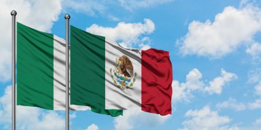 Nijerya ve Meksika bayrağı birlikte beyaz bulutlu mavi gökyüzüne karşı rüzgarda sallayarak. Diplomasi kavramı, uluslararası ilişkiler.