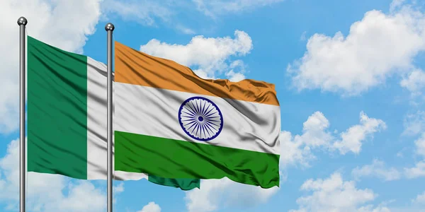 Bandera de Nigeria e India ondeando en el viento contra el cielo azul nublado blanco juntos. Concepto diplomático, relaciones internacionales . —  Fotos de Stock