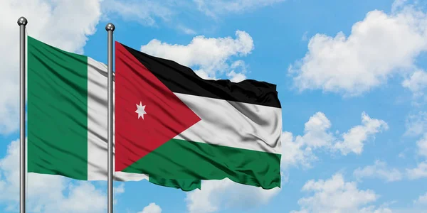 Drapeau du Nigeria et de la Jordanie agitant dans le vent contre ciel bleu nuageux blanc ensemble. Concept de diplomatie, relations internationales . — Photo