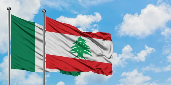Bandera de Nigeria y Líbano ondeando en el viento contra el cielo azul nublado blanco juntos. Concepto diplomático, relaciones internacionales . — Foto de Stock