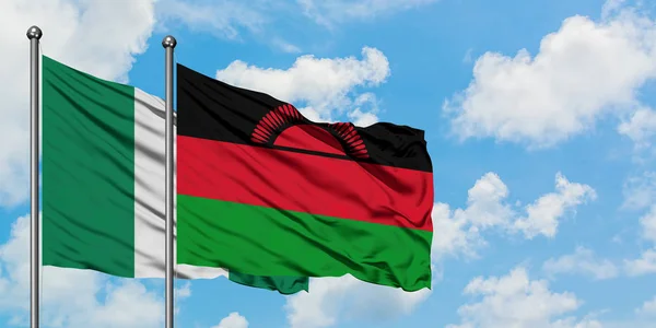 Nigeria und Malawi schwenken gemeinsam die Flagge im Wind vor dem wolkenverhangenen blauen Himmel. Diplomatie-Konzept, internationale Beziehungen. — Stockfoto