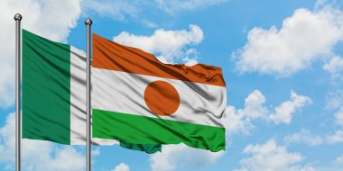 Nigeria and Niger flag waving in the wind against white cloudy blue sky together. Diplomacy concept, international relations.