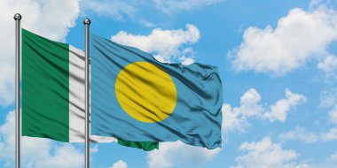 Nigeria and Palau flag waving in the wind against white cloudy blue sky together. Diplomacy concept, international relations.