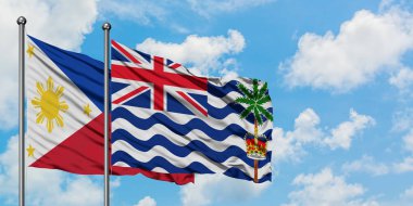 Filipinler ve İngiliz Hint Okyanusu Toprakları bayrağı birlikte beyaz bulutlu mavi gökyüzüne karşı rüzgarda sallayarak. Diplomasi kavramı, uluslararası ilişkiler.