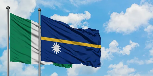 Nigeria und Nauru schwenken gemeinsam die Flagge im Wind gegen den wolkenverhangenen blauen Himmel. Diplomatie-Konzept, internationale Beziehungen. — Stockfoto