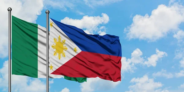 Bandera de Nigeria y Filipinas ondeando en el viento contra el cielo azul nublado blanco juntos. Concepto diplomático, relaciones internacionales . — Foto de Stock