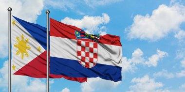 Filipinler ve Hırvatistan bayrağı birlikte beyaz bulutlu mavi gökyüzüne karşı rüzgarda sallayarak. Diplomasi kavramı, uluslararası ilişkiler.