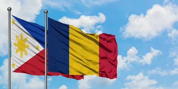 Bandera de Filipinas y Chad ondeando en el viento contra el cielo azul nublado blanco juntos. Concepto diplomático, relaciones internacionales . — Foto de Stock