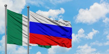 Nijerya ve Rusya bayrağı birlikte beyaz bulutlu mavi gökyüzüne karşı rüzgarda sallayarak. Diplomasi kavramı, uluslararası ilişkiler.