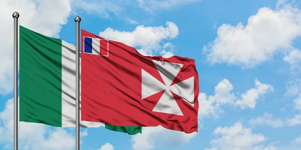 Nigeria y Wallis Y la bandera de Futuna ondeando en el viento contra el cielo azul nublado blanco juntos. Concepto diplomático, relaciones internacionales . — Foto de Stock
