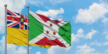 Niue ve Burundi bayrağı birlikte beyaz bulutlu mavi gökyüzüne karşı rüzgarda sallayarak. Diplomasi kavramı, uluslararası ilişkiler.