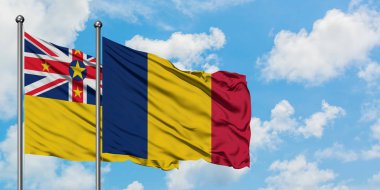 Niue ve Çad bayrağı birlikte beyaz bulutlu mavi gökyüzüne karşı rüzgarda sallayarak. Diplomasi kavramı, uluslararası ilişkiler.