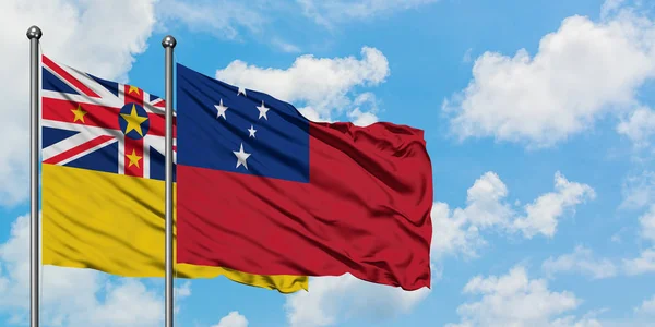 纽埃和萨摩亚国旗在风中飘扬，与白云蓝天相一起。外交概念、国际关系. — 图库照片
