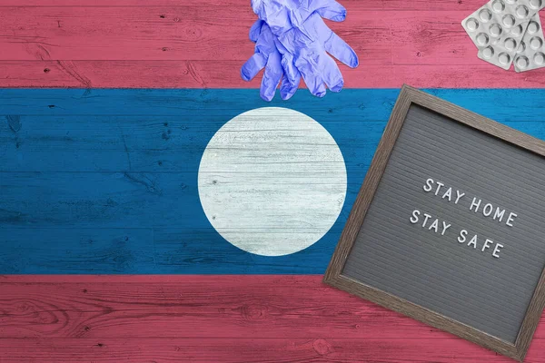 Laos Vlag Achtergrond Houten Tafel Stay Home Schrijfbord Chirurgische Handschoenen — Stockfoto